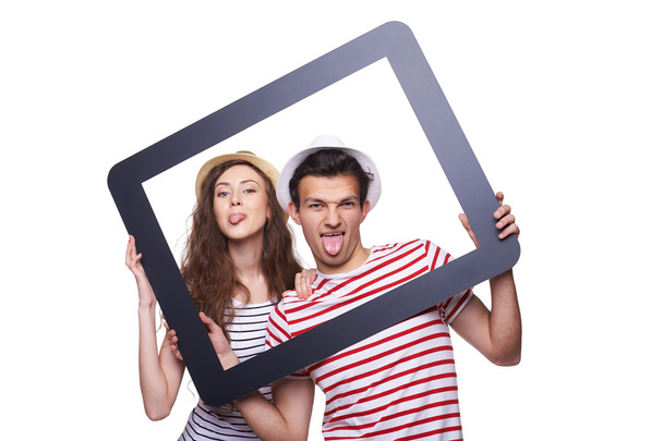 Happy couple showing tongue through tablet frame - Valokuva, kuva
