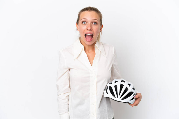 Beyaz arka planda bisiklet kaskı takan beyaz saçlı, sürpriz bir yüz ifadesi olan beyaz bir kadın. - Fotoğraf, Görsel