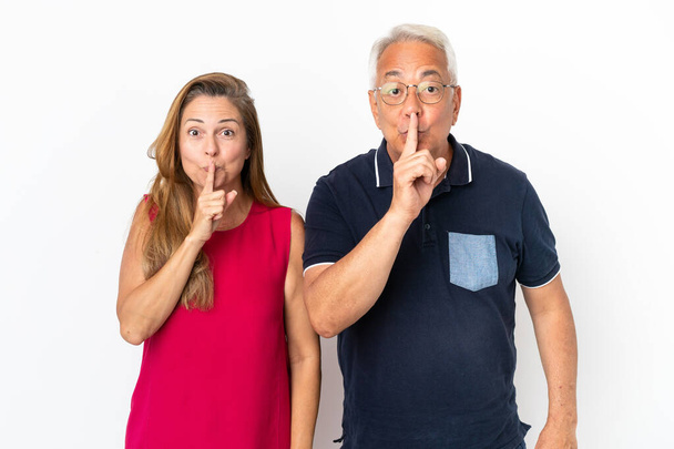 Middle age couple isolated on white background showing a sign of closing mouth and silence gesture - Photo, Image