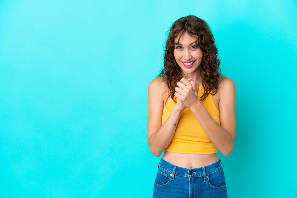 Young woman with curly hair isolated on blue background laughing - Foto, Imagen
