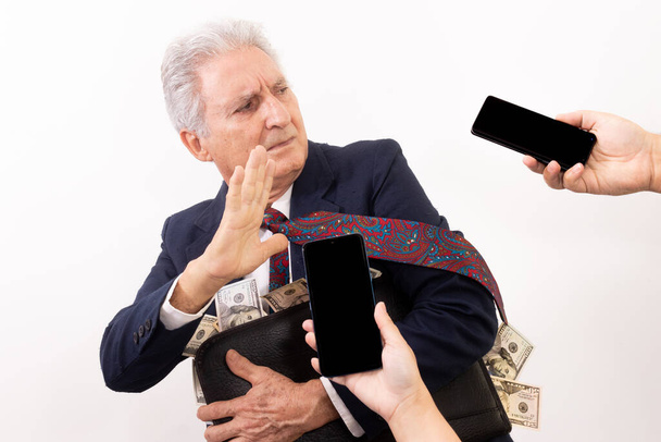 Hombre caucásico sosteniendo maleta llena de dinero, expresión fugitiva. - Foto, imagen