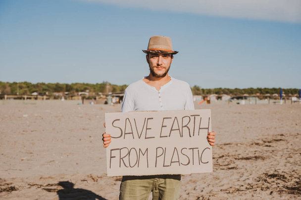 ビーチでプラスチック廃棄物を収集活動家。人々は、袋でビーチを掃除します。環境保全と海洋汚染問題の概念 - 写真・画像