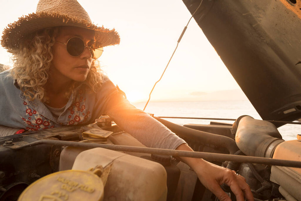 Young pretty woman check and repair engine car outdoor during alone travel  - 写真・画像