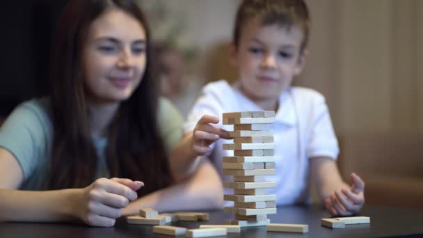 Mutter und Sohn spielen zu Hause Brettspiel mit Holzturm - Filmmaterial, Video