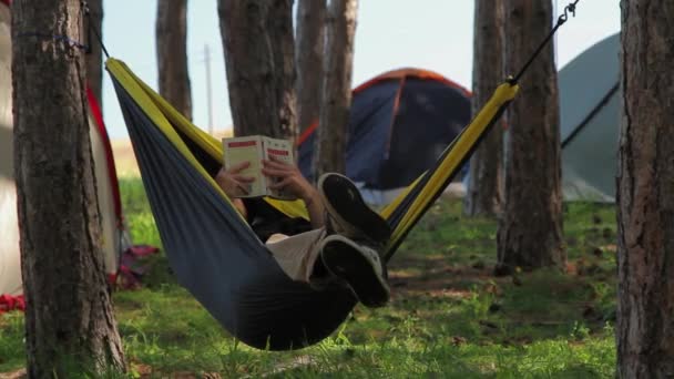 Teenager reading a book in a hammock - Footage, Video