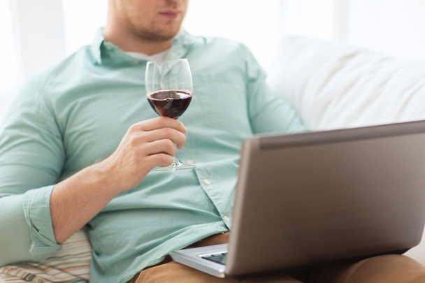 close up of man with laptop and wine glass - Foto, Bild