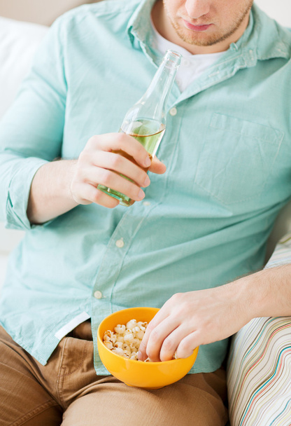 close up of man with popcorn and beer at home - Foto, Imagen
