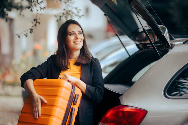 Cheerful Woman Taking Out Her Luggage from the Car Trunk  - Foto, Bild