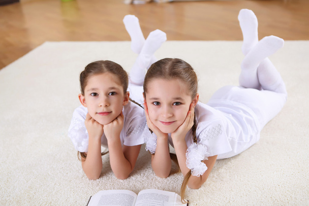Twin sisters together at home with books - Photo, image