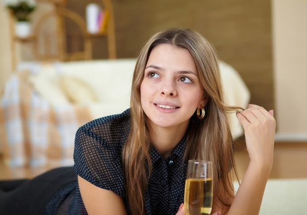 Young girl drinking champagne at home - Foto, Imagen
