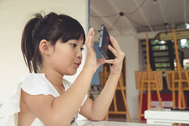 Little girl using smartphone, Social media concept. - Photo, Image