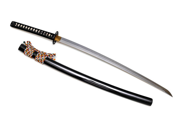 Японский меч стальной фитинг и красочный шнур с черными ножницами изолированы на белом фоне. Селективный фокус. - Фото, изображение