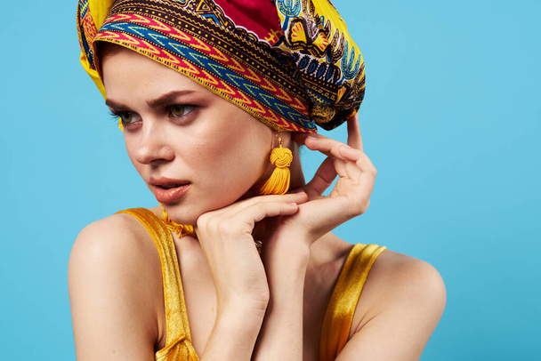 mooie vrouw etniciteit veelkleurige hoofddoek make-up glamor blauwe achtergrond - Foto, afbeelding