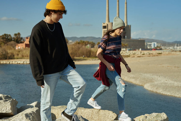 Two unconfined young people walking along the sea on rocks - Fotoğraf, Görsel