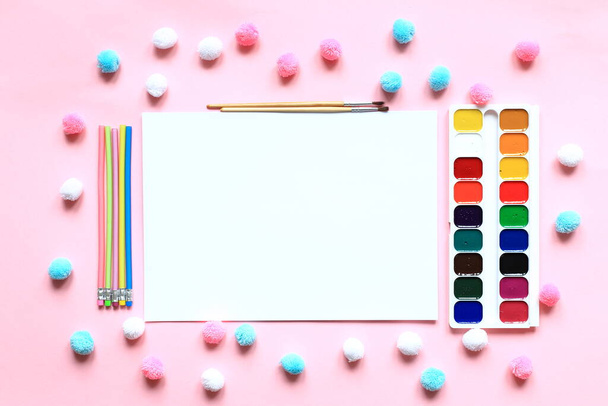 Een set verf en potloden voor het tekenen op een roze achtergrond. - Foto, afbeelding
