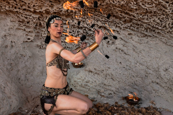 Cabo de Gata, Almeria, Hiszpania. Kobieta występująca z fankami ognia na plaży ćwicząca swój występ. - Zdjęcie, obraz