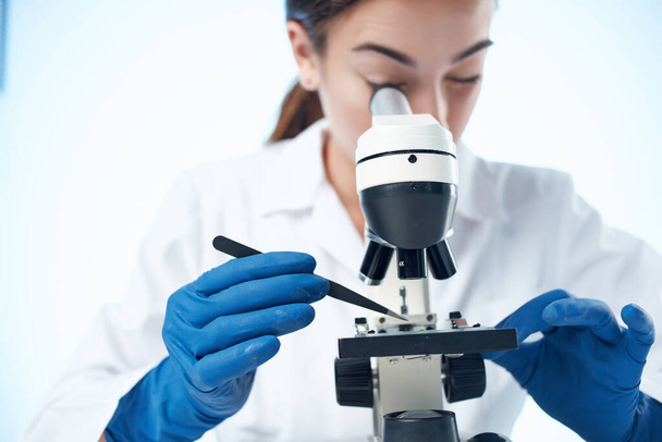 顕微鏡研究技術を通して見る女性研究室のアシスタント - 写真・画像