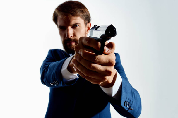 Der Mann im Anzug Geheimagent mit einer Pistole in der Hand eines Verbrechens Licht Hintergrund - Foto, Bild