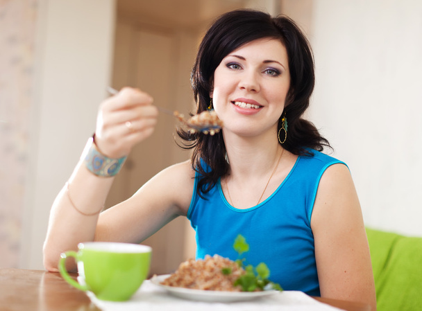 Pretty woman eats buckwheat - Zdjęcie, obraz