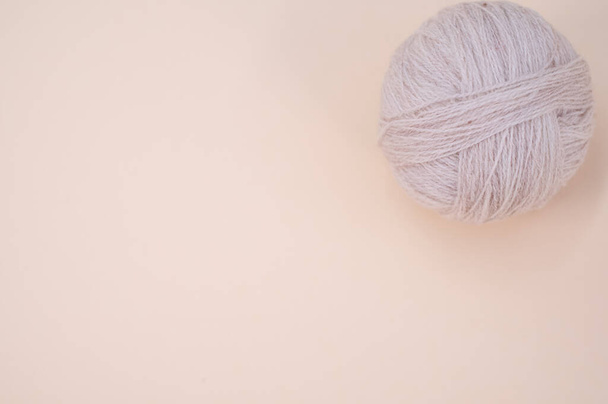 A vertical shot of isolated grey yarn on a beige background with text space - Foto, Imagem