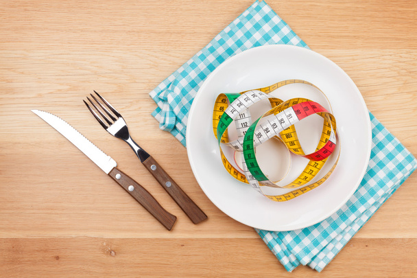 Plate with measure tape, knife and fork. - Foto, Imagen