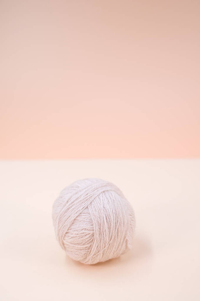A vertical shot of isolated grey yarn on a beige background with text space - 写真・画像