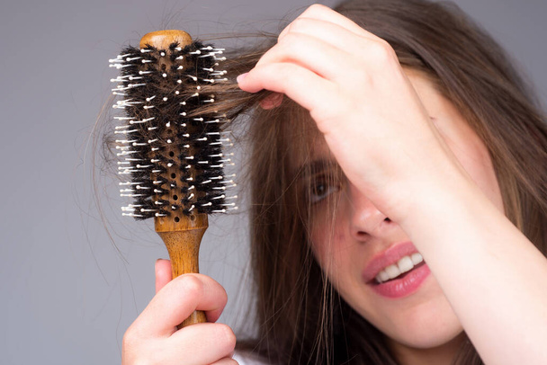 Stressed woman is very upset because of hair loss. Haircut and straightening hair care. Serious hair loss problem for health care shampoo. - Zdjęcie, obraz
