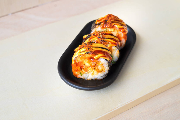 Nourriture coréenne, gimbap ou kimbap dans une assiette sur un fond en bois. - Photo, image