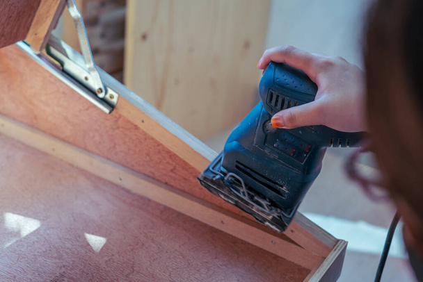 Hand sanding wood with a machine in the craftsman workshop. - Foto, Bild