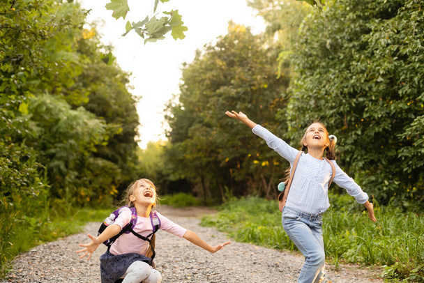 Kaksi söpöä hymyilevää 8-vuotiasta tyttöä poseeraa yhdessä puistossa aurinkoisena syyspäivänä. Ystävyyden käsite
. - Valokuva, kuva