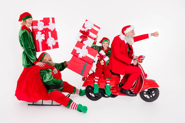 Foto de quatro pessoas animadas passeio trenó ciclomotor entregar saco desgaste santa elfo traje isolado cor branca fundo - Foto, Imagem