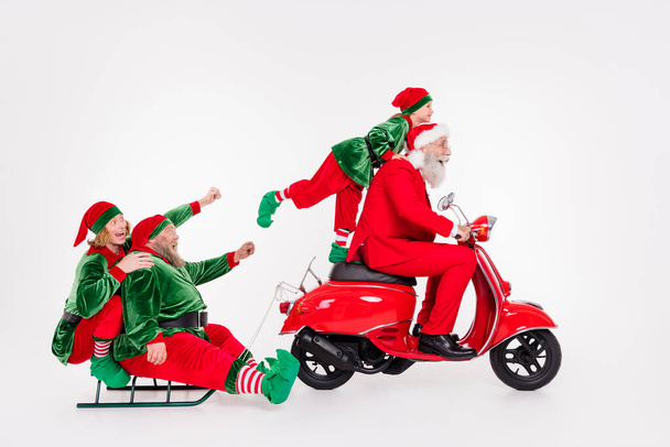 Portrait of attractive cheerful four people riding scooter sledge December time isolated over white color background - Fotografie, Obrázek