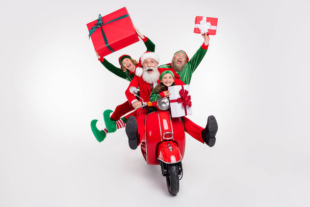 Portrait of attractive cheerful four people riding scooter delivering gifts boxes eve tradition isolated over white color background - Photo, Image