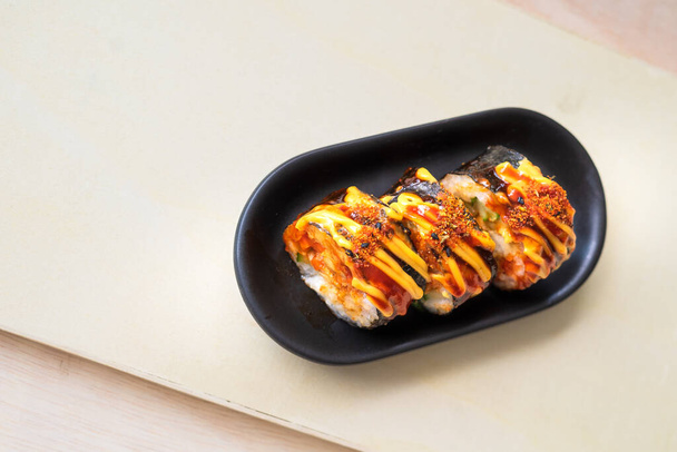 Comida coreana, gimbap ou kimbap em uma placa em um fundo de madeira. - Foto, Imagem