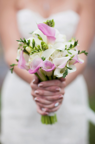 Pink and white bridal bouquet of calla lilies in the hands of th - Φωτογραφία, εικόνα