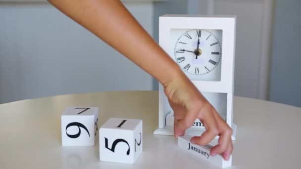 A white flip clock on table turns through month, flipping days and date. January 1st on the calendar. - Footage, Video