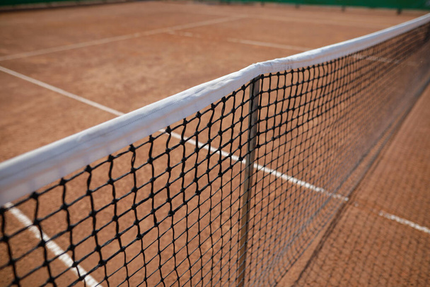 Profundidade de campo rasa (foco seletivo) imagem com a rede de uma quadra de tênis de barro. - Foto, Imagem