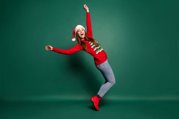 Full size profile photo of funny millennial lady dance wear sweater cap jeans boots isolated on green background - 写真・画像