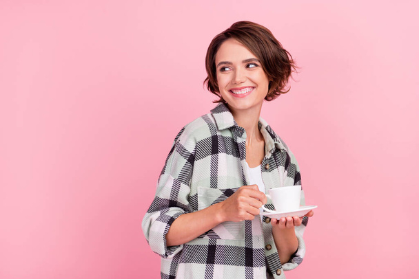 Photo of young woman happy positive smile drink coffee break look empty space isolated over pink color background - Foto, Imagen