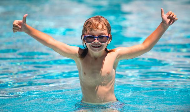 Cute child boy swim in swimming pool, summer water background with copy space. Funny kids face. Excited funny child in sunglasses in pool in summer day. - Foto, Bild