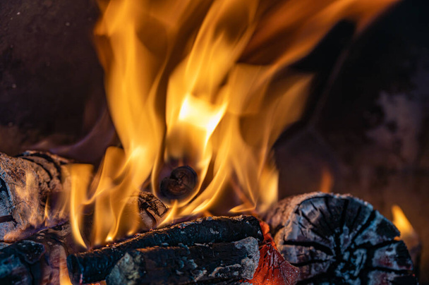 Red, orange and yellow flames from firewood in a oven - Photo, Image
