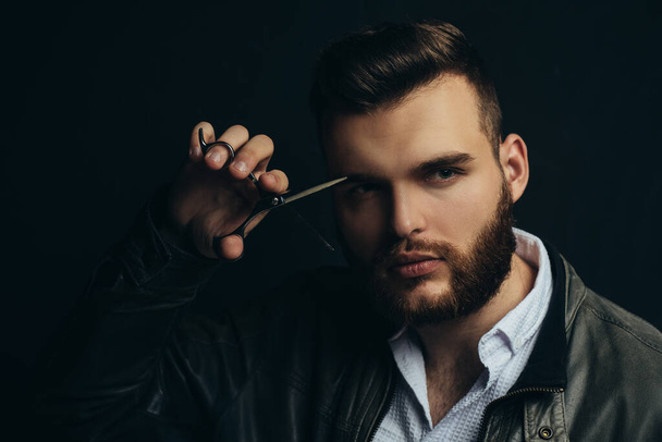 Close up portrait of young sexy man, portrait of guy with barber scissors for barber shop. Modern barbershop, shaving. Handsome male with modern hairstyle on black. - Fotografie, Obrázek