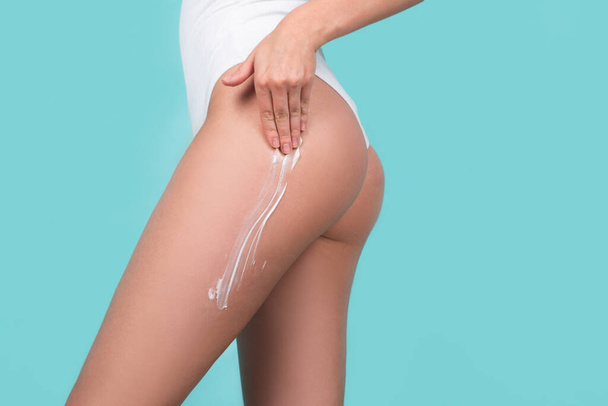Perfect female buttocks. Cosmetic cream on woman buttocks with clean soft skin. Applying moisturizer cream on butt. Cellulite or anti cellulite treatment. Body care and spa salon concept. - 写真・画像