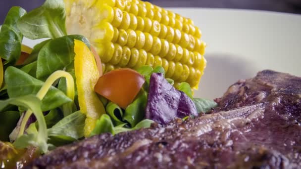 t-bone steak s grilovanou kukuřicí - Záběry, video