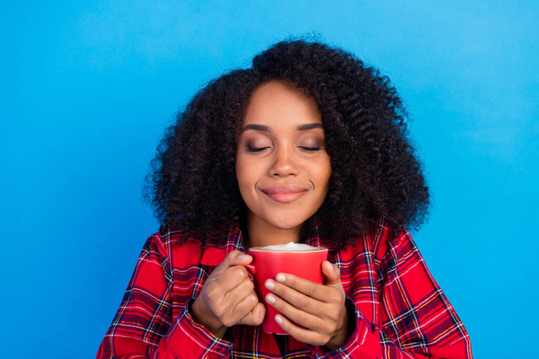 Fotografie sladký zbytek tisíciletá dáma pít kávu oblečení červená kostkované pyžama izolované na modrém pozadí - Fotografie, Obrázek