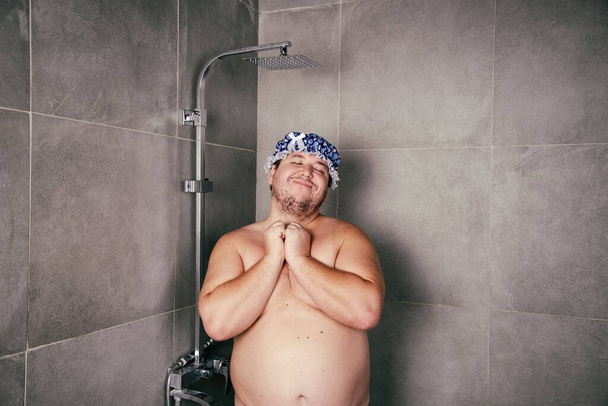 Vicces kövér ember fürdik a zuhanyzóban.. - Fotó, kép