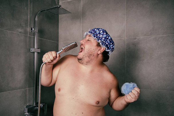 Divertente grasso uomo lava sotto la doccia. - Foto, immagini