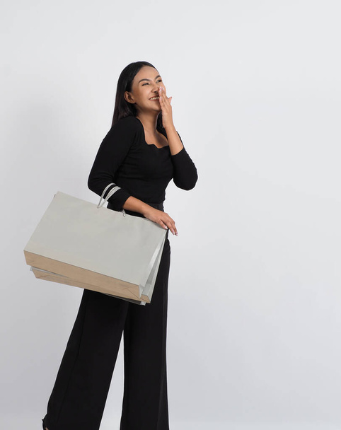Woman shopping concept. Happily girl and shopping bags during sale season. Happy young asian Thai woman in action or activity of purchasing goods from stores or online shop and white background. - 写真・画像