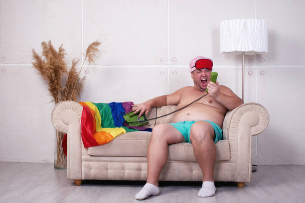 Hombre gordo divertido está descansando en el sofá en casa. - Foto, imagen