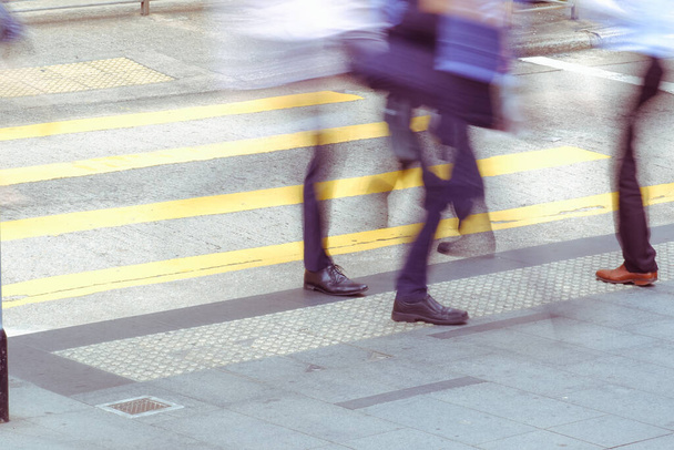 piernas de gente de negocios caminando en el cruce de cebra en hora punta - Foto, Imagen